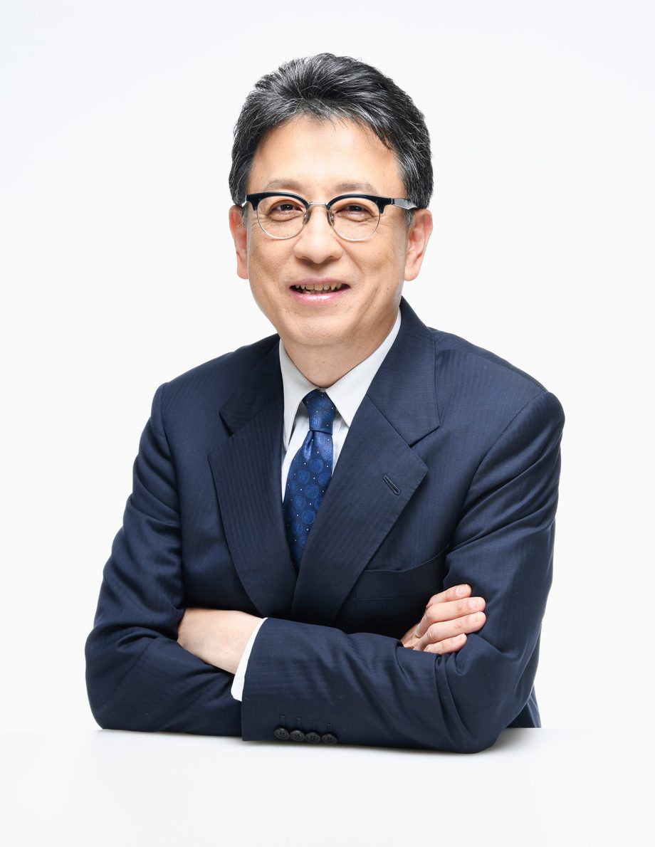 腕を組んでほほえむ大西一史